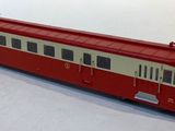 a red and white train on the tracks in the snow