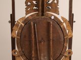a clock that is on a stand on a white surface