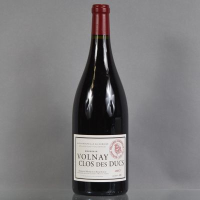 La bouteille de vin rouge est posée sur une table en verre.