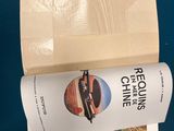 a book on the table next to a cup of coffee and a cell phone