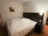 a bed with a white blanket on it in a room