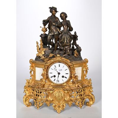 une horloge en or sur laquelle figurent un homme et une femme