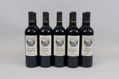 four bottles of wine are lined up on a white surface