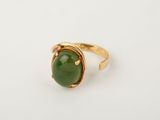 a gold ring with a green jade stone on it