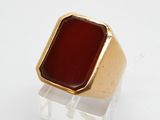 une image d'une bague en or avec une pierre rouge au centre