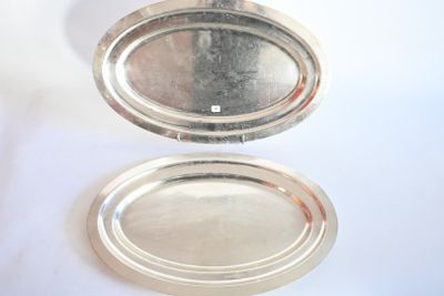 deux plateaux en argent posés l'un à côté de l'autre sur une table
