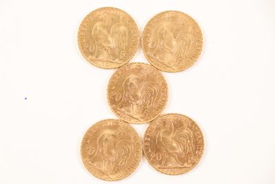 four gold coins are arranged in a pyramid on a white surface
