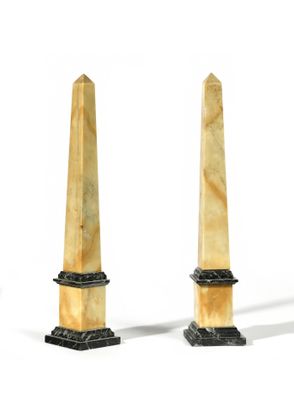 pair of marble obelisks on pedestals on a white background
