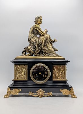 une statue de femme assise au sommet d'une horloge