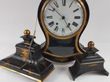 a black and gold clock sitting on top of a white table
