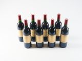 six bottles of red wine lined up in a row on a white surface