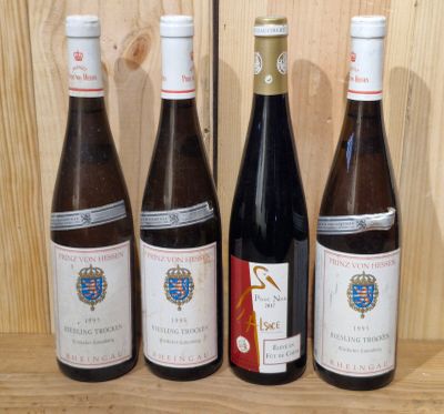 four bottles of wine are lined up on a wooden shelf