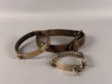 trois bracelets différents, munis de chaînes, posés sur une surface blanche
