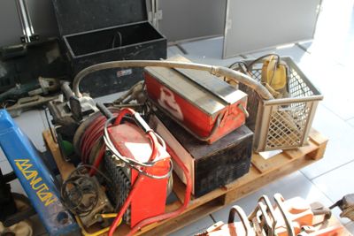 un tas d'outils posés sur une palette dans un garage