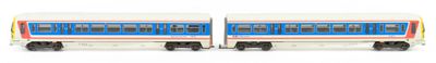 two trains that are sitting side by side on a white surface