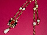 a close up of a necklace on a pink surface