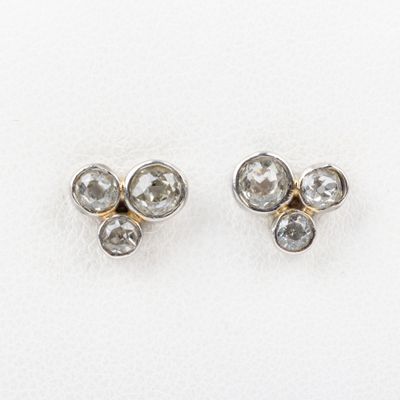 une paire de boucles d'oreilles en diamant sur une surface blanche