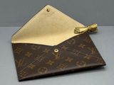 un portefeuille Louis Vuitton contenant une clé, posé sur une table