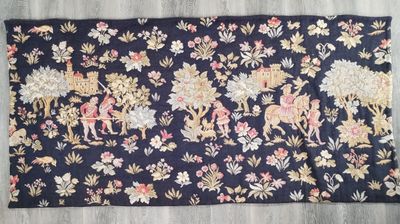 un gros plan d'un tapis posé sur un parquet, orné de fleurs et d'animaux