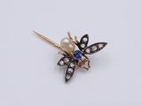 a close up of a brooch with a pearl and diamond flower