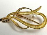 une image d'une broche en or sertie d'une perle