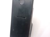 the back of a black cell phone sitting on top of a white surface