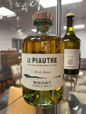 a bottle of whisky sitting on a table in front of two bottles