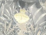 a clear glass vase with a gold emblem on it
