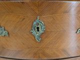 a wooden chest of drawers with a marble top