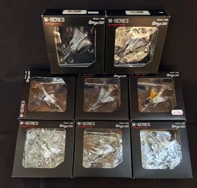 six maquettes d'avions de chasse dans leurs boîtes, posées sur une table