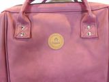 purple leather handbag with a leather handle on a white background
