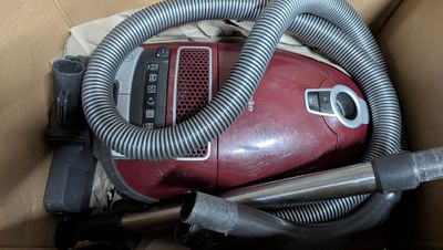 un aspirateur rouge qui se trouve à l'intérieur d'une boîte