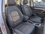 the interior of a car with grey leather seats and steering controls