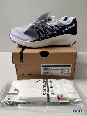 une paire de chaussures New Balance dans une boîte posée sur une table