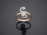 a gold ring with two diamonds on a black surface
