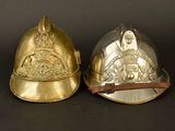 pair of brass fire helmets on a black background with a black background