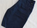 navy blue pants laying on a white sheet on a bed