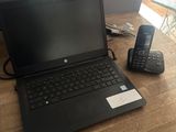 un ordinateur portable et un téléphone posés sur une table en bois