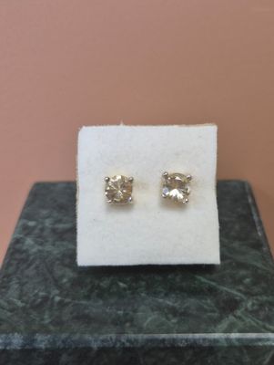 une paire de boucles d'oreilles en diamant posée sur un tissu blanc