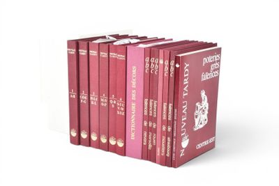 six livres rouges sont alignés sur une surface blanche