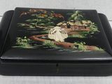 an image of a black box with a painting of a woman sitting on a bridge