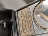 a magnifying glass and a book in a metal box