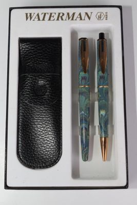 deux stylos et un étui dans la boîte posée sur la table