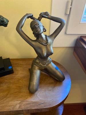 a statue of a woman sitting on a table next to a horse