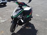 a motorcycle parked in a parking lot with a car in the background