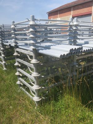many rows of metal benches in the grass near a building