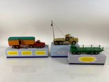 trois camions miniatures exposés sur une surface blanche