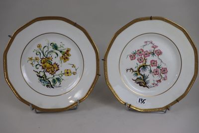 two plates with floral designs on them are sitting on a table