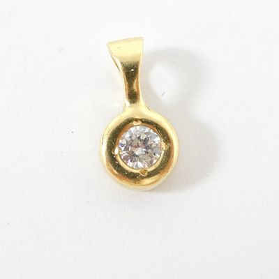 gros plan d'un pendentif en diamant sur une surface blanche