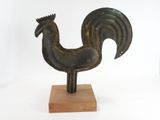 statue of a rooster on a wooden base on a white background